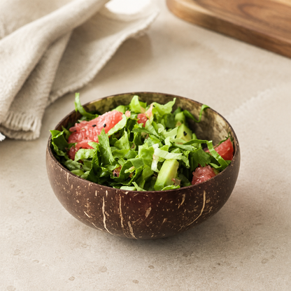 Coconut shell serving bowl on a warm cream stone surface