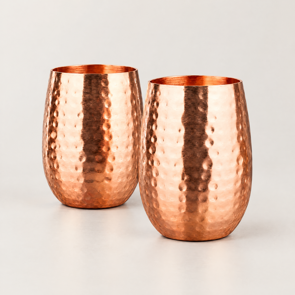 A pair of hammered copper cocktail cups side by side