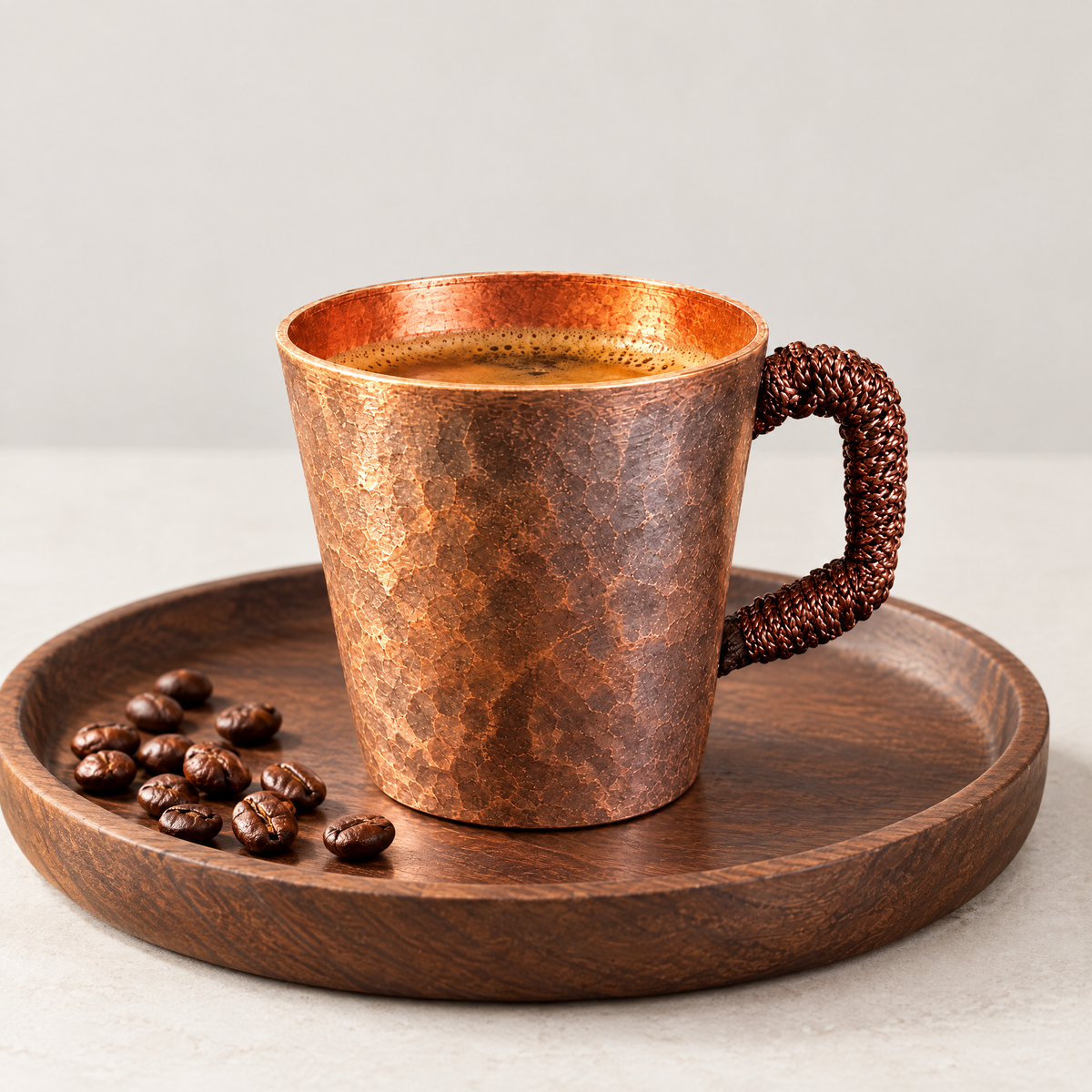 Copper espresso cup on a tray with coffee beans