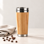 Bamboo travel mug on a desk with coffee beans and linen