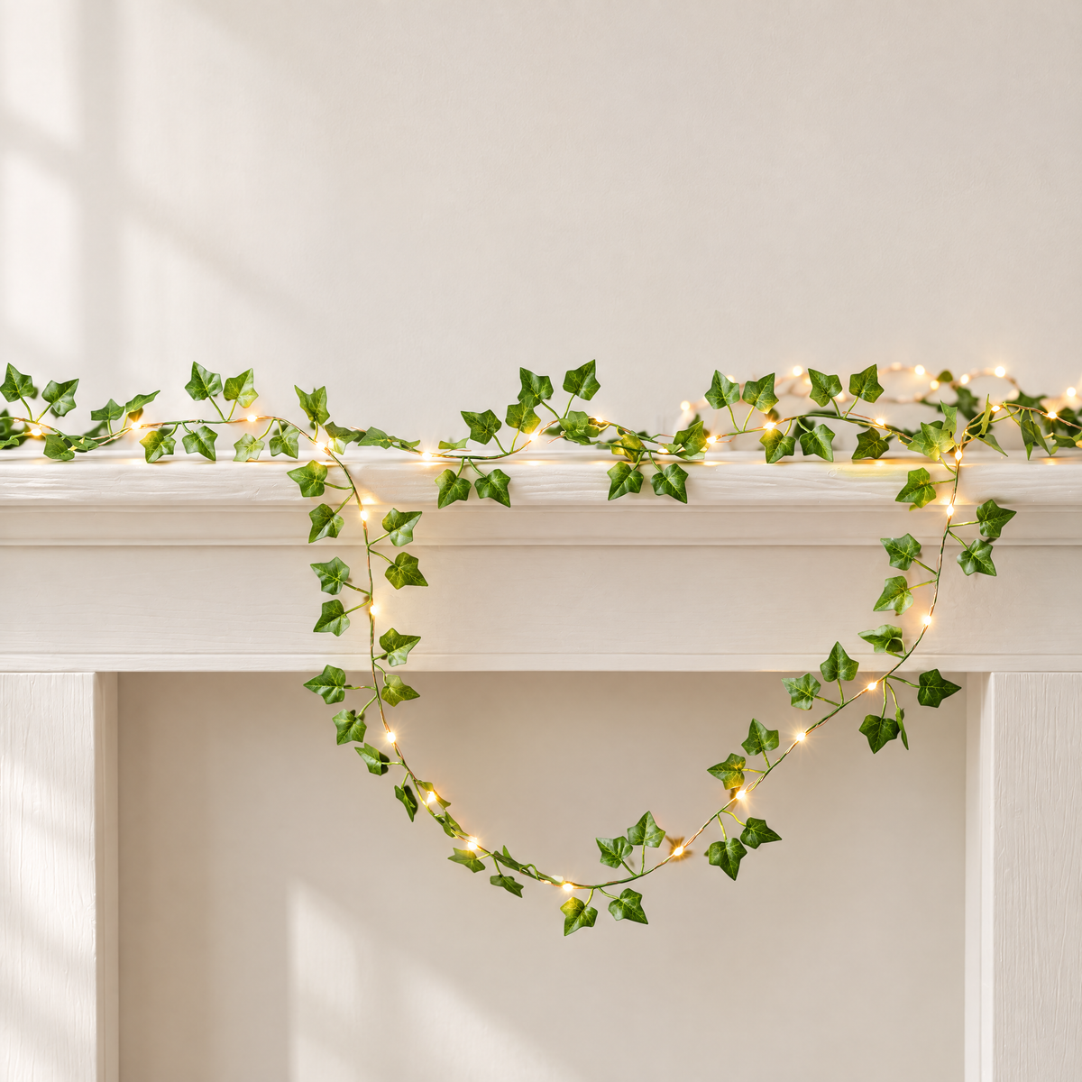 Ivy leaf fairy lights draped along a mantelpiece