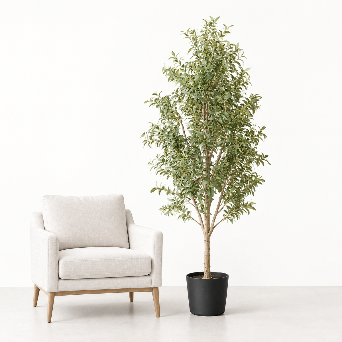 Artificial olive tree beside an armchair for scale