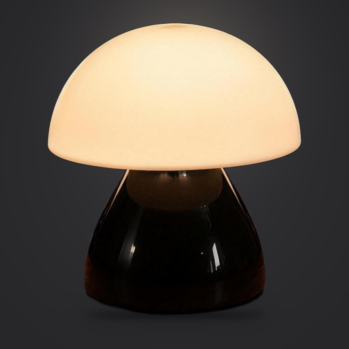 Rechargeable cordless table lamp, Black option, lit with a soft glow, on a plain charcoal background